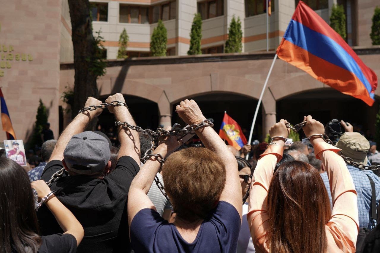 Demonstranten ketten sich symbolisch vor dem Gebäude des Untersuchungsausschusses aneinander (Foto: "Tawusch für die Heimat", 4. Juni 2024)