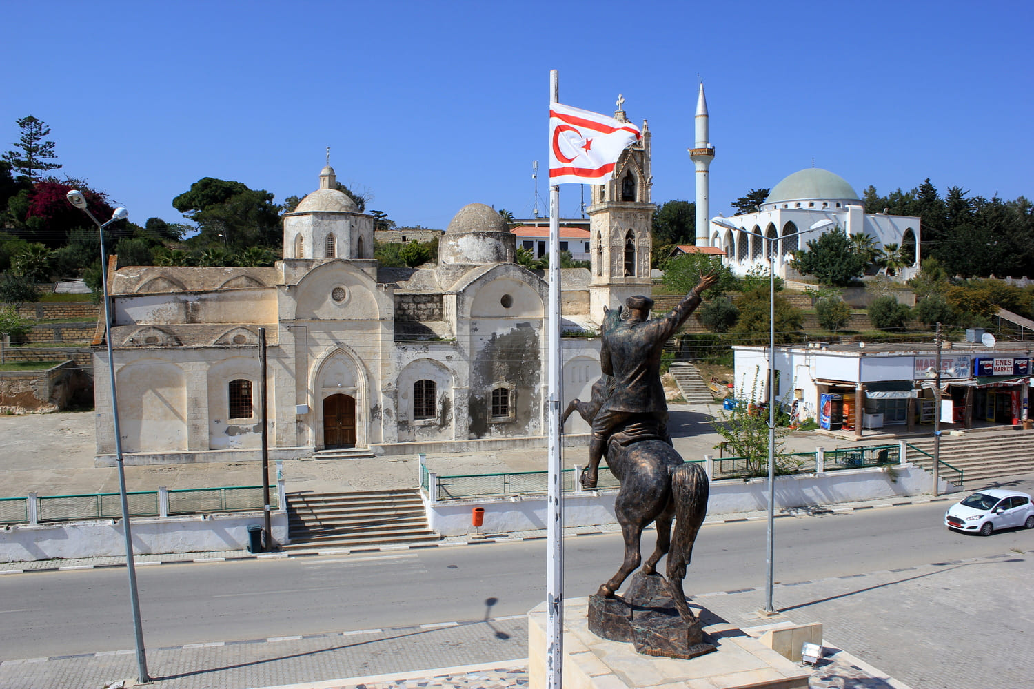 Ortskern von Rizokarpaso/Dipkarpaz auf der Karpas-Halbinsel, Zypern, mit der Agios-Synesios-Kirche, der Moschee und dem Atatürk-Denkmal. Foto: Julian Nyča - CC BY-SA 3.0